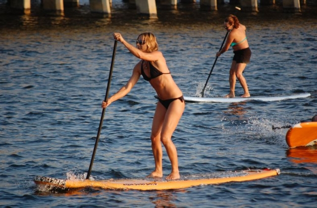 dos chicas practicando sup en el mar